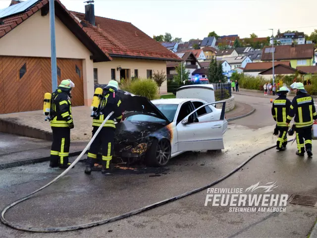 Löscharbeiten mit einem Angriffsrohr unter Atemschutz an einem brennenden Pkw